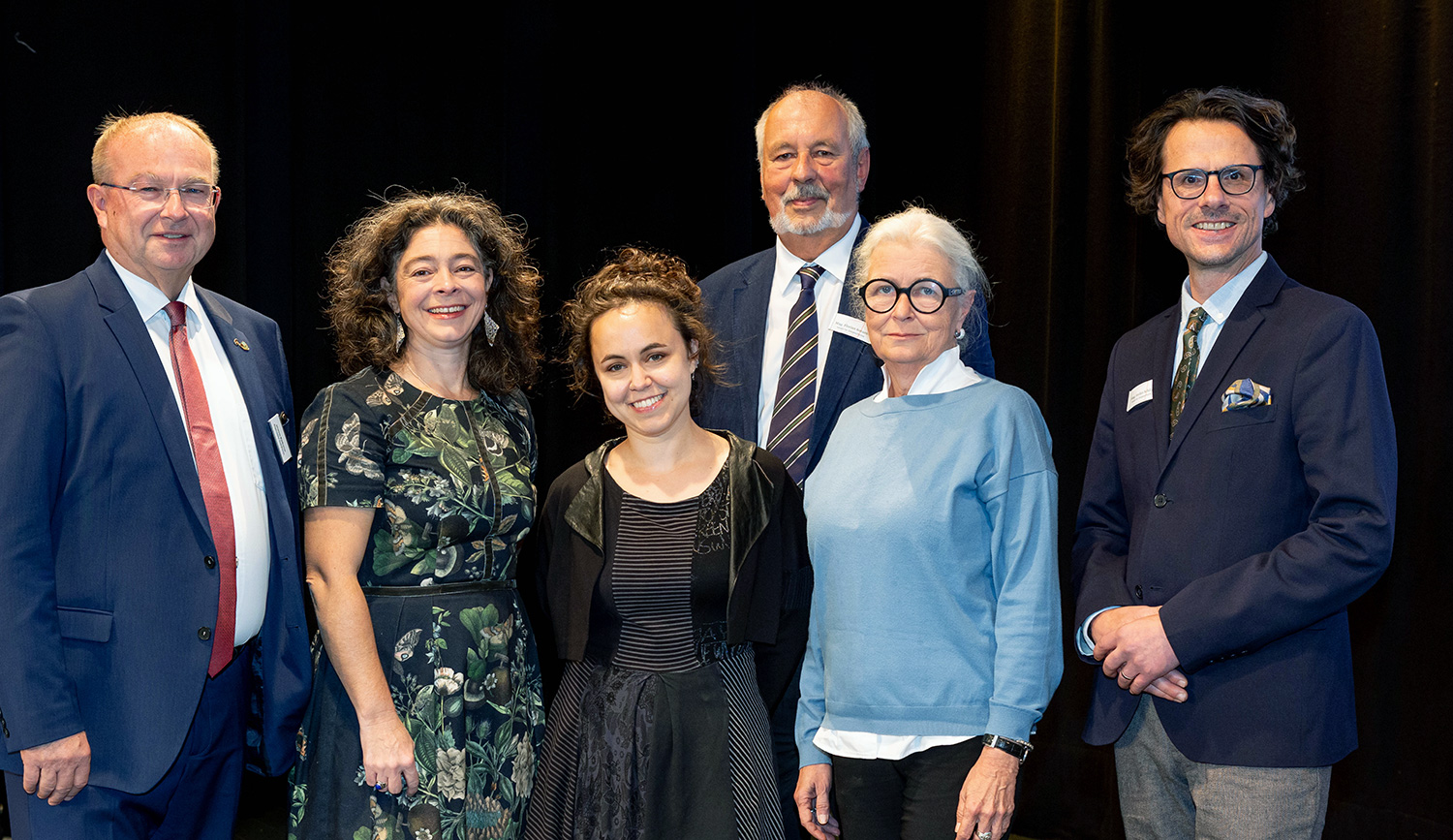 Die Gerichtspsychiaterin Heidi Kastner und die Journalistin Anna Goldenberg eröffneten die Zeitgeschichte-Tage Braunau 2026, flankiert von Bürgermeister Johannes Waidbacher, Antonia Plessing, Florian Kotanko und Stefan Schlögl. Foto: VZG/Photogräfin